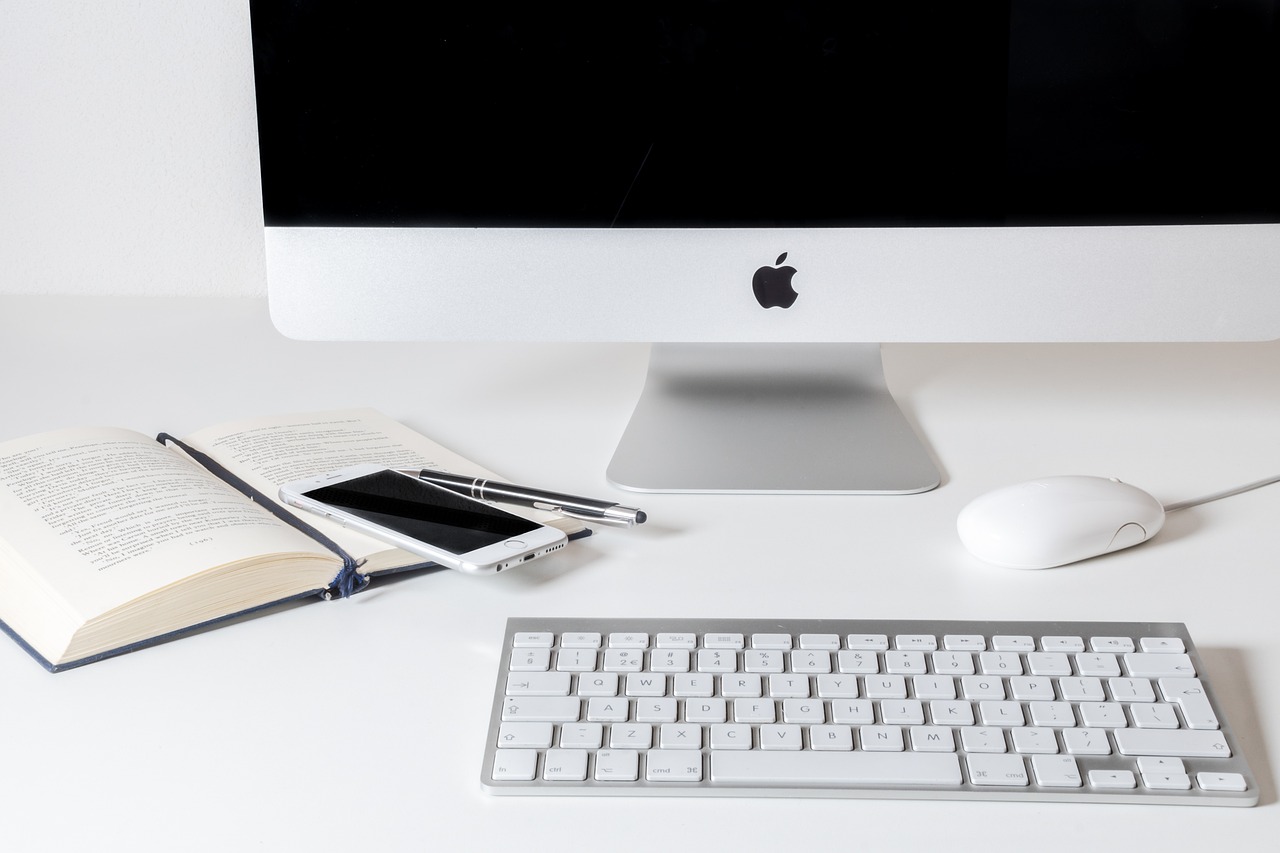 Desktop Home office desk set up with iMac and notebook, representing remote business support
